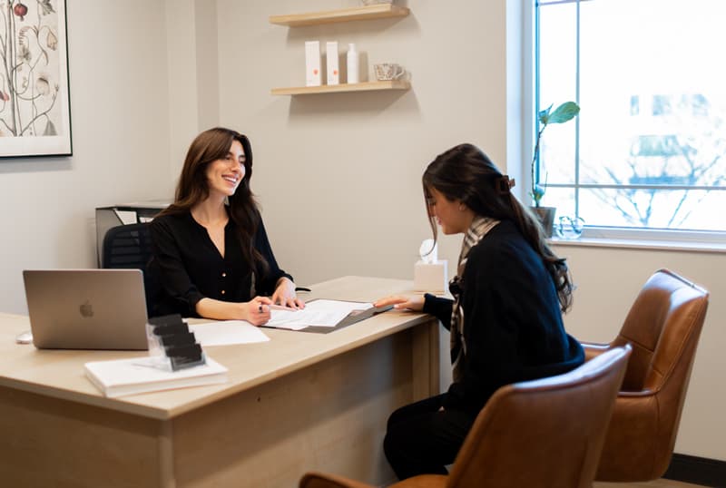 Erin, Patient Care Coordinator, consulting a patient in her office.