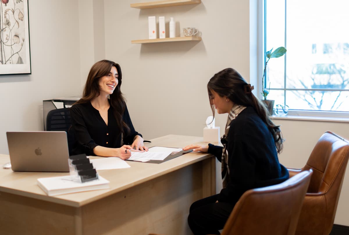Erin, Patient Care Coordinator, consulting a patient in her office.