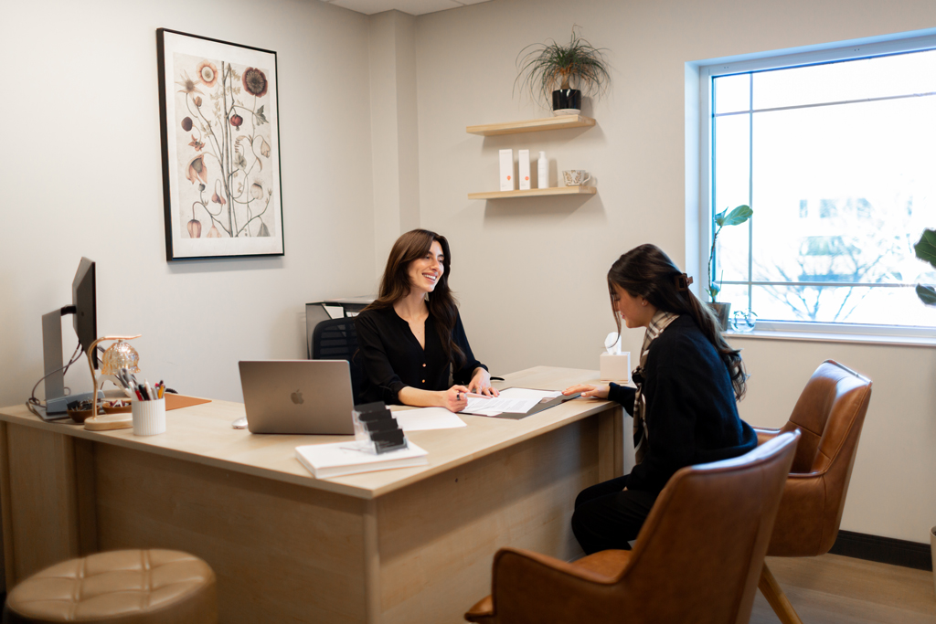 Patient Care Coordinator Erin consulting a patient in her office